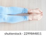 Small photo of Female legs in a socks bend and unbend feet, home workout concert, top view.