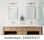 Small photo of A cozy bathroom detail with a white oak vanity cabinet, white countertop, bronze faucets and lights and a white herringbone tile backsplash.