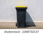 Yellow dustbin or trash can or black dustbin or trash can with yellow lid