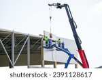 Small photo of Sandwich panels wall assembly using telescopic boom crane and two self propelled articulating boom lifts, sandwich panels wall mounting