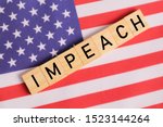 Small photo of Concept of US politics, Impeachment showing with US flag with Impeach in wooden letters.