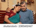 Small photo of Indian senior husband consoling his worried crying wife at home - concept of emotional family support, companionship and kindness