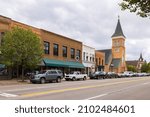 Small photo of Hillsdale, Michigan, USA - October 21, 2021: The business district on Broad Street with the St Anthony Catholic Church on the background