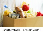 Small photo of Donation box with various food. Open cardboard box with butter, canned goods, cereals and fruits.