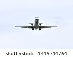 White Bombardier CRJ-900 is landing. The turbo-ventilator plane is white, clear. Photo from the bottom of the plane. The plane is landing at Rzeszow-Jasionka Airport.