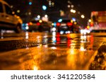 Rainy night in the big city, dense traffic at a busy intersection. View from the level of asphalt