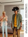 Small photo of A young mixed race couple is at their new home using an augmented reality headset to see the outlay of their new apartment once finished decorating.