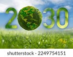 Numbers 2030 with green planet. A symbol of sustainable development and transition to renewable energy by 2030 year.