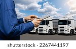 Small photo of Manager with a digital tablet next to trucks. Fleet management