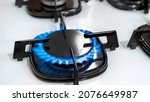 Small photo of Close up shot of blue fire from domestic kitchen stove top. Gas cooker with burning flames of propane gas. Gas supply chain and news. Global gas crisis and price rise.