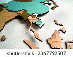 Small photo of Asia on the political map. Wooden world map on the wall. Thailand, Vietnam, Indonesia, Cambodia, Malasia countries