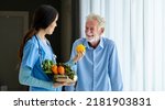 Small photo of Hospice caregiver nurse and nutritionist is suggesting variety of vegetable to Caucasian man at pension retirement center for the home care rehabilitation and longevity post treatment recovery process