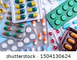 Different tablets, pills in foil blister packs, medications drugs on blue background