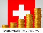Small photo of Upgoing graph made of coins stacked in front of Swiss flag. Concept of quick financial development of Switzerland