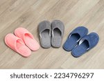 Small photo of Warm male and female slippers on parquet floor in room at home. Home shoes, getting warmer, slippers for guests concept