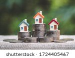 Mini house on stack of coins, Concept of Investment property, Investment risk and uncertainty in the real estate housing market.