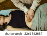 Small photo of visceral abdominal massage for a young woman, Osteopathic Manipulation and CranioSacral Therapy. Non-traditional medicine. Health care
