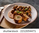 Small photo of Pork roulade with pickles and bacon, served with fried mushrooms and green onions.