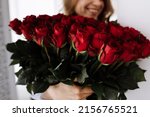 Happy Valentine's Day. smiling young woman holding a big luxury bouquet of red roses flowers. Celebration of engagement or wedding. Birthday gift