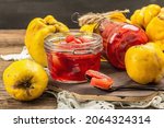 Small photo of Homemade quince jam in a glass jar. Fresh fruits, sweet marmalade,vintage arrangement. Old wooden background, close up