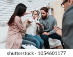 Small photo of Untuned parents try to reach out to little girl in headphones. Deficiency of attention in child. Family at consultation with family psychologist.