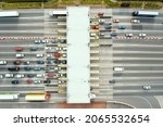 Small photo of An overhead view of a busy toll road with many cars queuing up to pay the highway toll