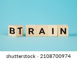 Small photo of Train Your Brain. Turns a cube and changes the word 'train' to 'brain' on wooden cubes. Dice form the words train and brain. Business and train your brain concept.