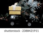 black toy car carrying gifts jewelry. Christmas decorations. The concept of Christmas mood and preparation for the celebration. Discounts present. Black Friday. 2024. Seasonal sale, big discounts