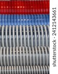 Small photo of New colorful plastic spiral hoses closeup. A lot helical reinforced pipes industrial backdrop texture pattern