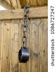 Small photo of Old vintage rusty iron medieval chains or shackles, used for locking up prisoners or slaves between 1600 and 1800, on a barns wooden, background. Shackles of slaves, place of the execution of heretics