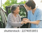Female helper to help a senior woman get out of her car