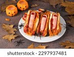 Small photo of Themed food for Halloween - hot dog with bloody sausage fingers in ketchup buns and carrot