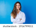 Young girl in lab coat on blue background with space for text. Woman with white coat. Concept of healthcare professional