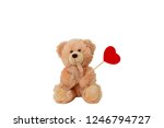 Teddy bear is holding a red heart on a stick. White isolate