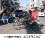 Small photo of Bandung, West Java, Indonesia - July 10, 2023. Two becak or pedicabs on a roadside in Bandung City. Becak's are used in Bandung and are one of the cheapest ways of getting around.
