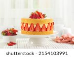 Festive French Fraisier Cake made with two layer of Genoise Sponge, Diplomat Cream and Fresh Strawberries. Delicious Summer Fruit Cake with fresh berries on a holiday table.