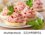 Close-up of Italian canapes with mortadella and ricotta cream mousse or Spuma di mortadella on a small tigelle bread. Decorated with toast almonds, pepper. Appetiser or snacks for a festive table.