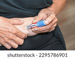Small photo of Gosford, New South Wales Australia – April 30 2023, Women injecting herself in the stomach with an Ozempic semaglutide needle