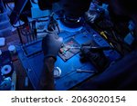 Small photo of Hands in gloves of cellphone maintenance engineer work on chipset pins of removed microprocessor from smartphone motherboard with tweezers and soldering iron. Close-up macro photo, Selective focus