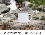Small photo of Blank enamel coffee mug, white camping cup mockup in wild nature.