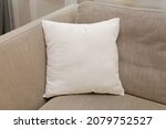 White square canvas pillow mockup on cozy couch, small cotton cushion mockup in living room interior., space for design presentation.