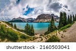 Mountain lake under the clouds. Beautiful mountain lake panorama. Mountain lake panoramic landscape. Lake in mountains