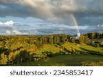 Small photo of Rainbow over the valley landscape. Rainbow over rural church. Countryside church under rainbow in sky. Rainbow in sky