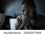 dramatic home portrait of young sick and depressed black African American girl sitting on bed  upset and sleepless at night feeling overwhelmed suffering depression and anxiety problem