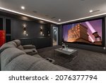 Media theatre room with dark walls grey sofa popcorn movie screen interior residential room
