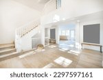 Small photo of spacious foyer entry to an entry with dappled sunshine jute ottoman wooden bench open door with bright light shining in to a dual white wood railed stairway