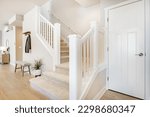 Small photo of Bright and airy entry foyer with white wall stair case light colored hard wood flooring dark walnut front door entry coat rack hooks to a welcoming interior