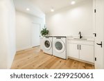Small photo of Clean white laundry room with front loading machines tile flooring large and spacious home interior
