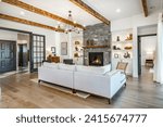 Small photo of Interior living room with fireplace stone and wood mantle staircase wooden flooring decorated and staged large bright windows classic and modern decor
