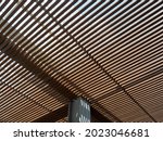 Wooden slats roof, architecture construction with sunlight streaming through and making beautiful shadow line.